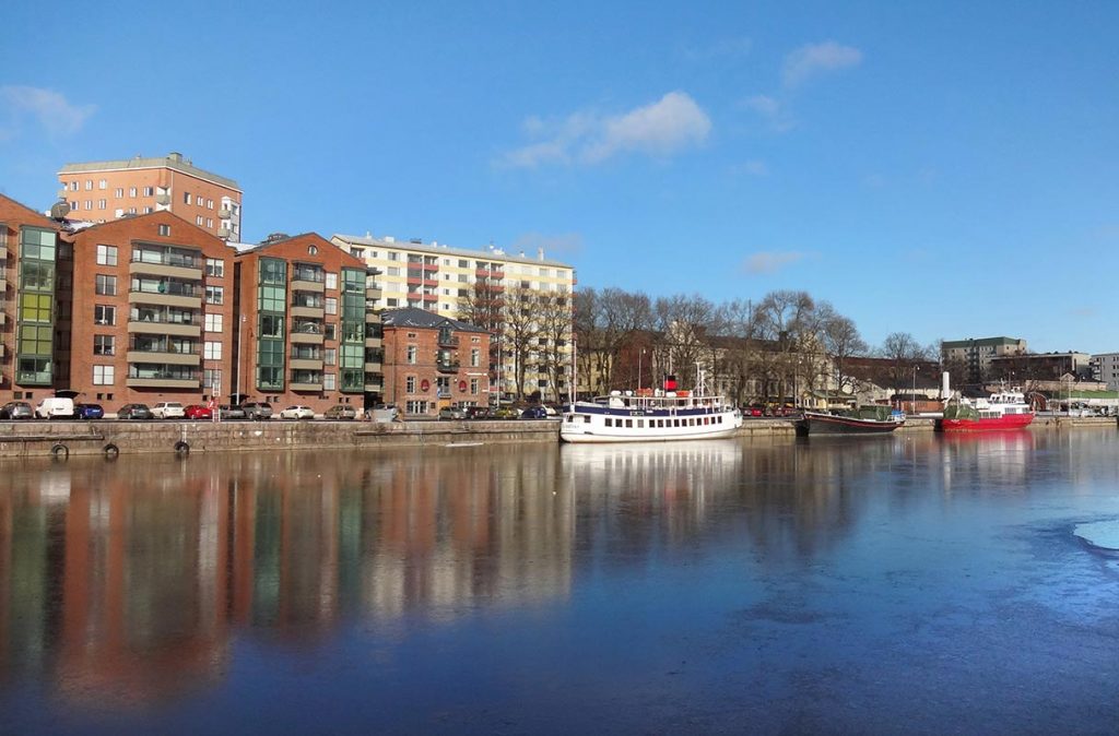 Eine Häuserreihe und Boote am Fluss in Turku